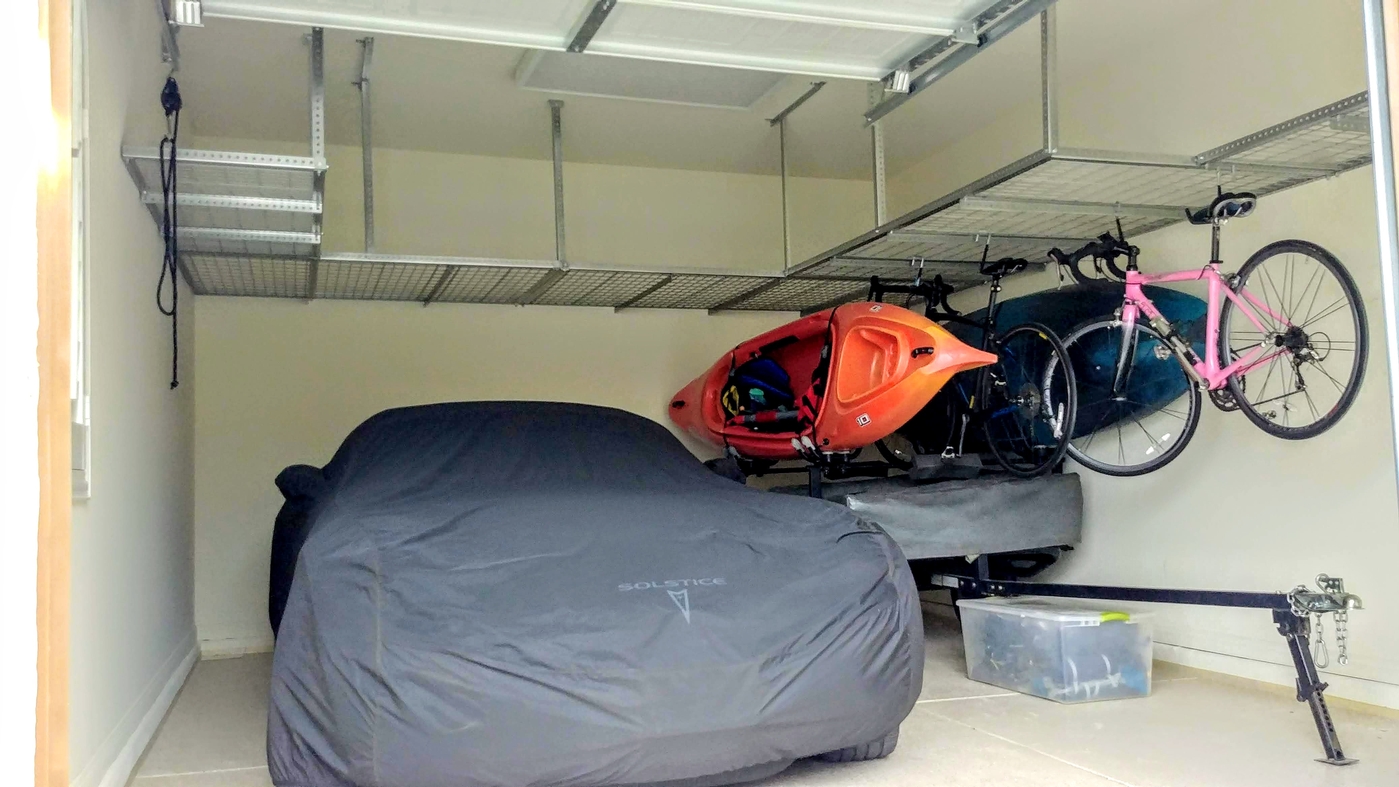 Overhead ceiling storage racks with hanging kayak and bikes